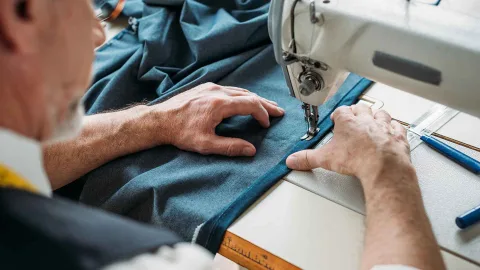 A man working on a sewing machine.