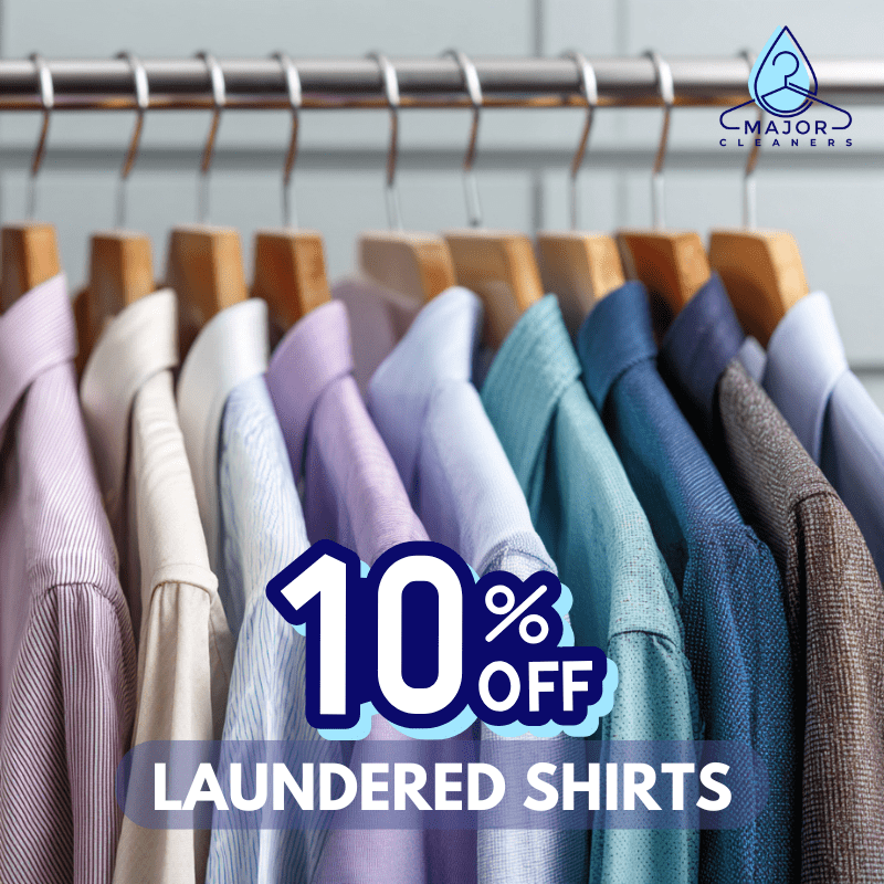A row of freshly laundered shirts hanging on a rack with a sign offering 10% off laundered shirts from Major Cleaners.
